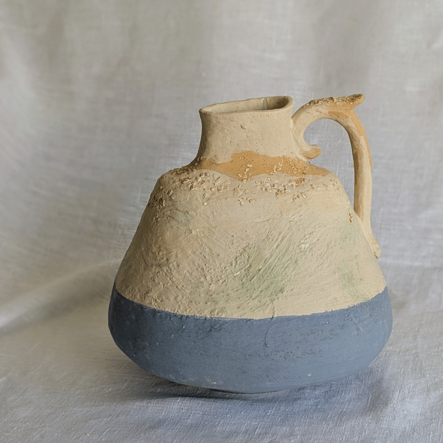 Pieza artesanal de barro rojo con técnica de churro, decorada con engobes y óxidos metálicos en tonos azul, blanco y terroso