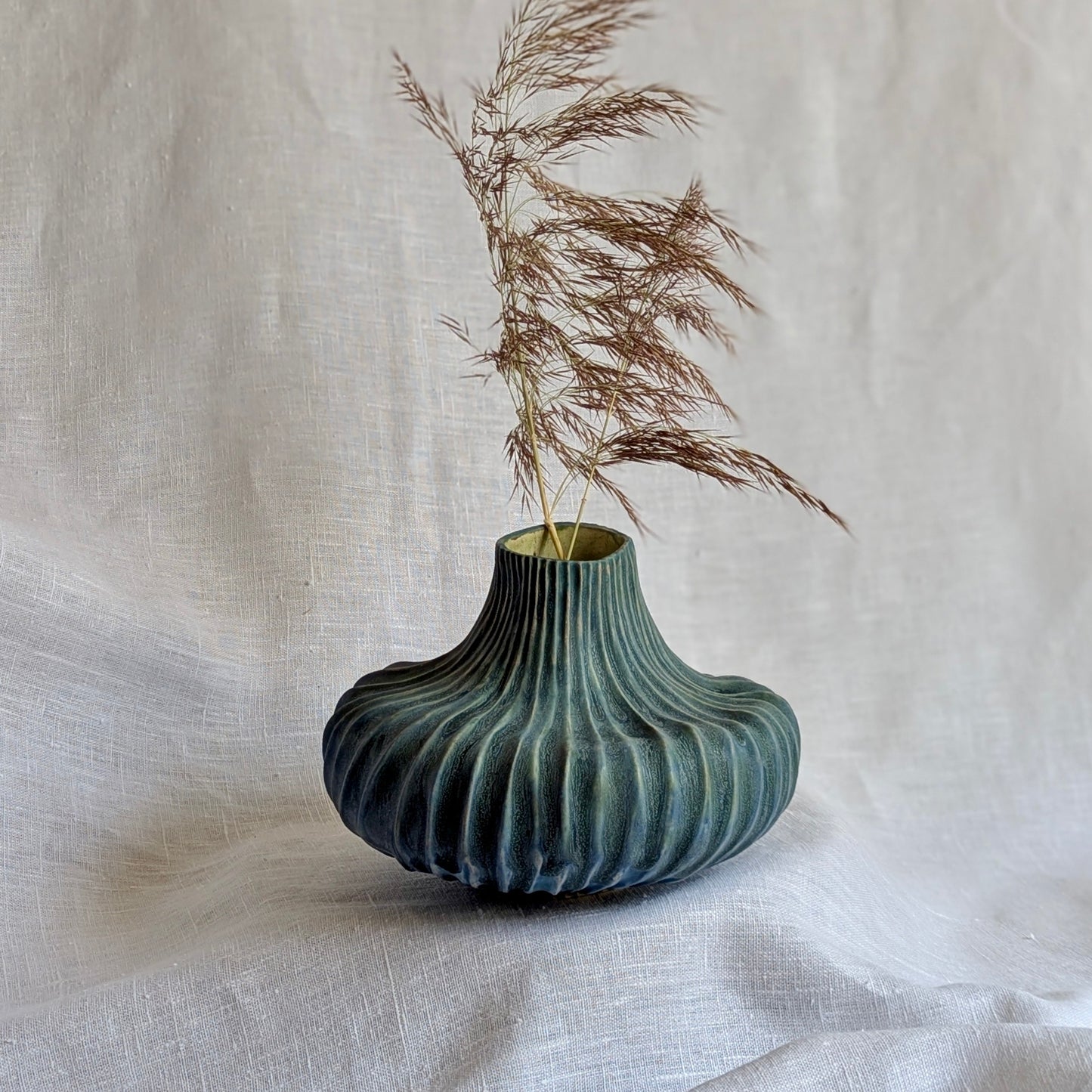 pieza escultórica de gres blanco con esmalte azul inglés, cerámica artesanal contemporánea con textura ondulada