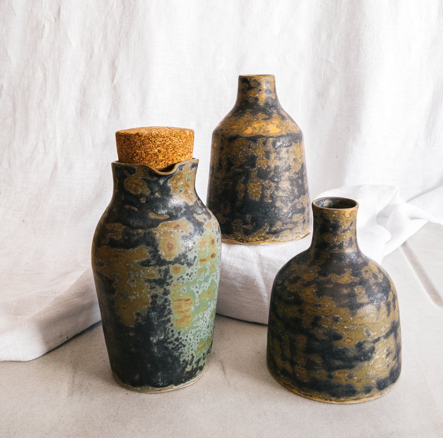 botella artesanal en terracota con esmalte verde reactivo y acabado moteado