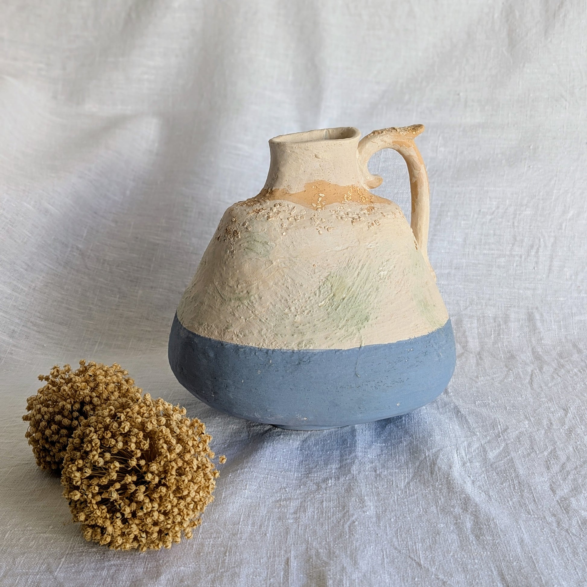 Pieza artesanal de barro rojo con técnica de churro, decorada con engobes y óxidos metálicos en tonos azul, blanco y terroso