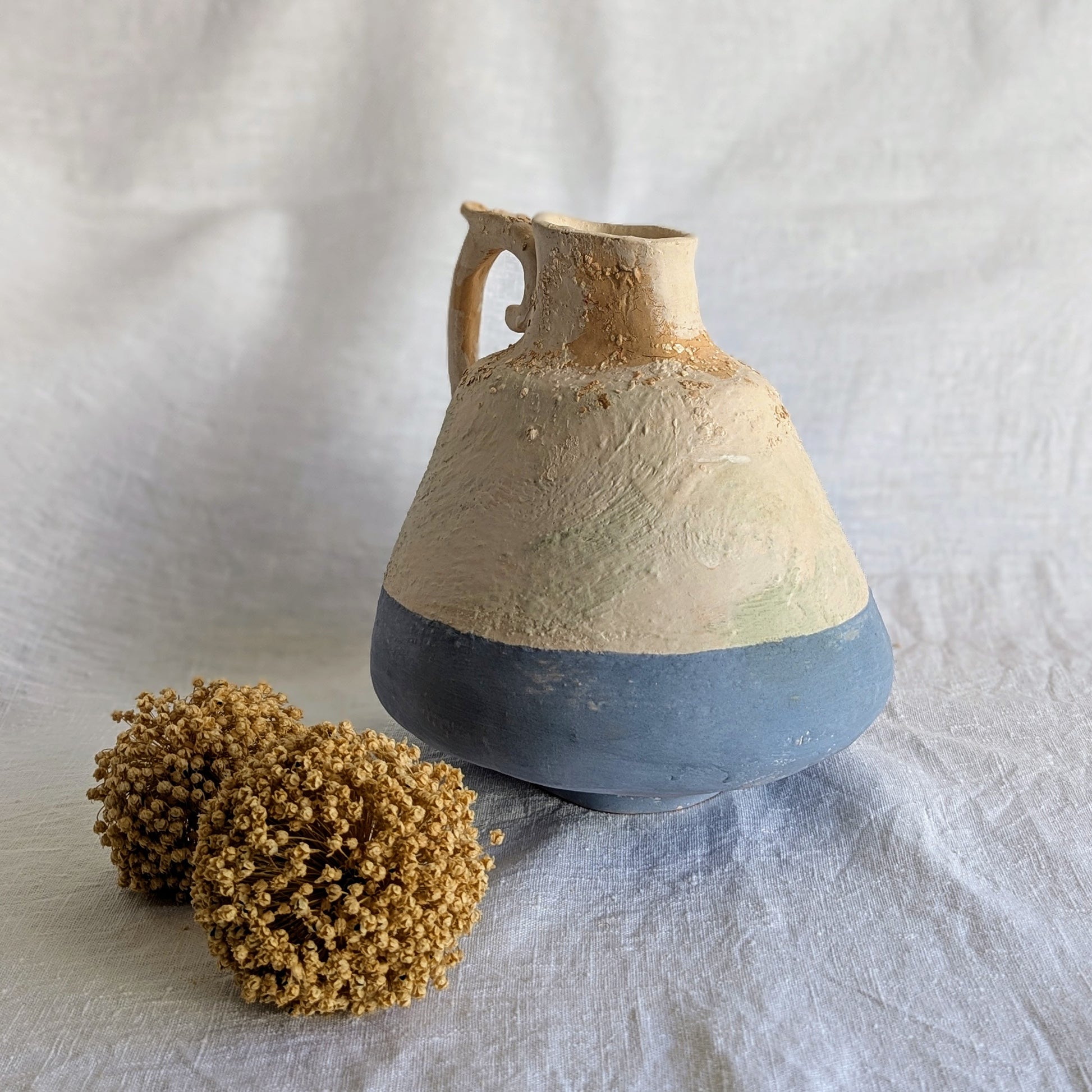 Pieza artesanal de barro rojo con técnica de churro, decorada con engobes y óxidos metálicos en tonos azul, blanco y terroso