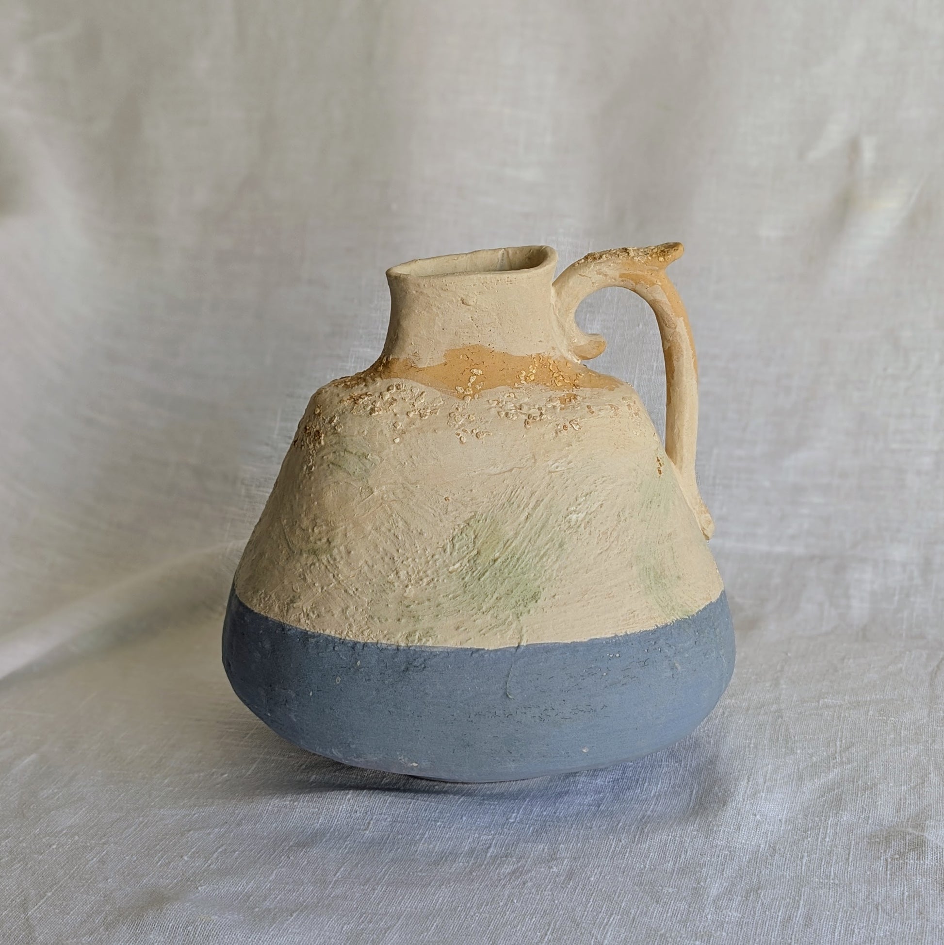 Pieza artesanal de barro rojo con técnica de churro, decorada con engobes y óxidos metálicos en tonos azul, blanco y terroso