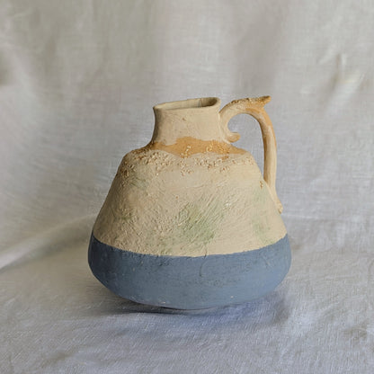 Pieza artesanal de barro rojo con técnica de churro, decorada con engobes y óxidos metálicos en tonos azul, blanco y terroso