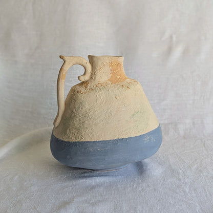 Pieza artesanal de barro rojo con técnica de churro, decorada con engobes y óxidos metálicos en tonos azul, blanco y terroso