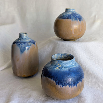 Piezas escultóricas de gres blanco torneadas a mano con esmalte parcial en tonos profundos, serie Otra posible Tierra