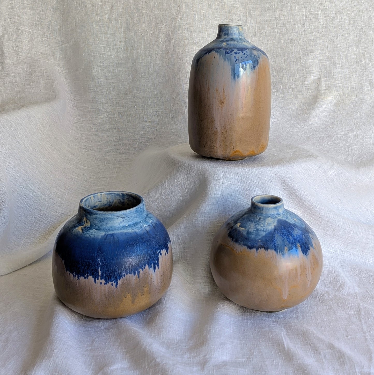 Piezas escultóricas de gres blanco torneadas a mano con esmalte parcial en tonos profundos, serie Otra posible Tierra