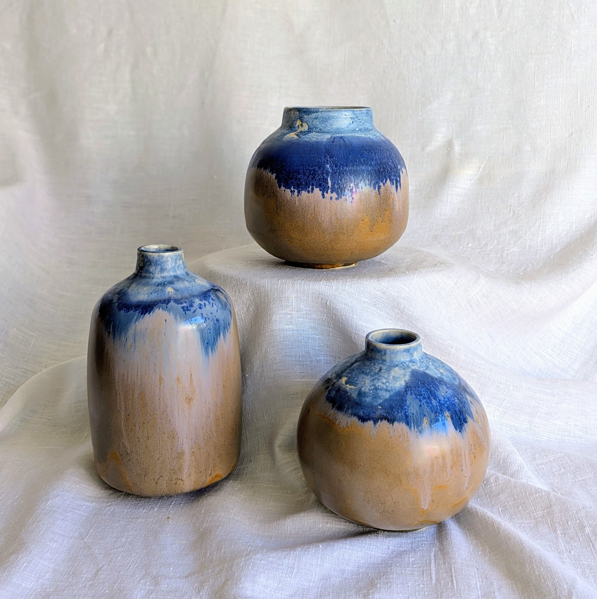 Piezas escultóricas de gres blanco torneadas a mano con esmalte parcial en tonos profundos, serie Otra posible Tierra