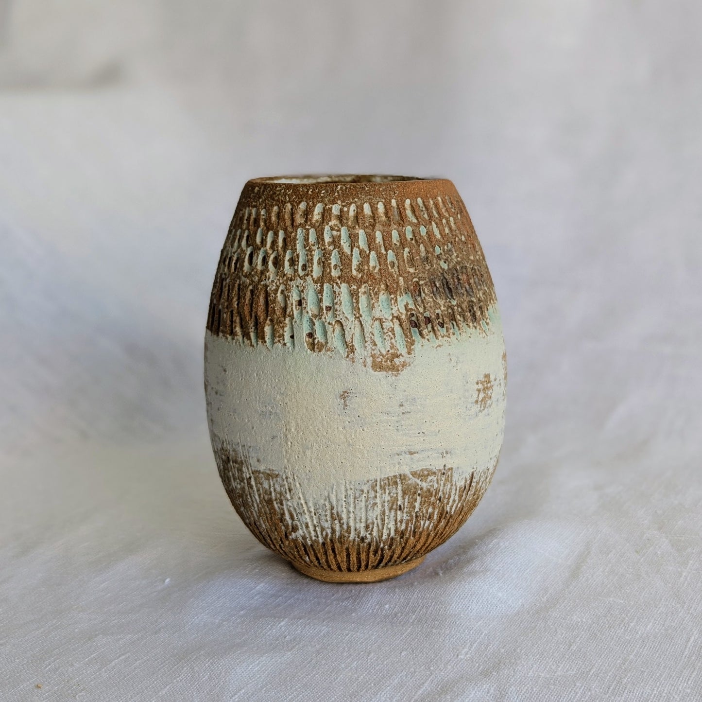 Vaso ovalado de gres marrón con chamota fina, esgrafiado a mano y esmaltado mate con veladuras en verde turquesa