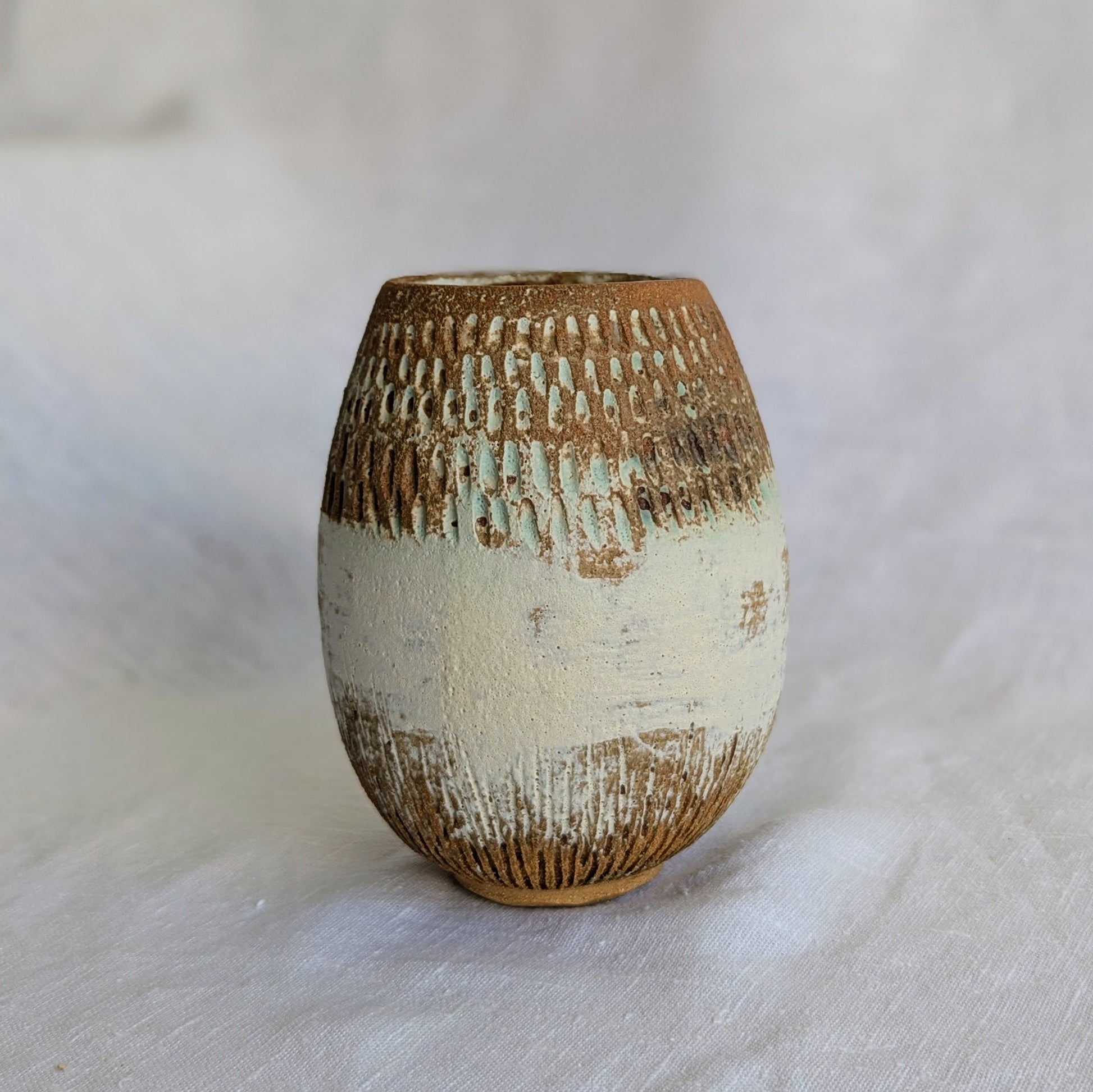 Vaso ovalado de gres marrón con chamota fina, esgrafiado a mano y esmaltado mate con veladuras en verde turquesa