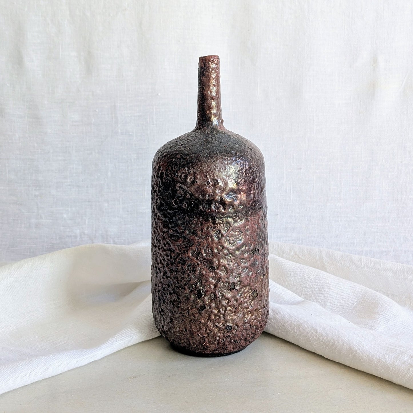 Pieza decorativa de cerámica rakú en gres blanco con acabado metálico hecha a mano por Laloba Cerámica