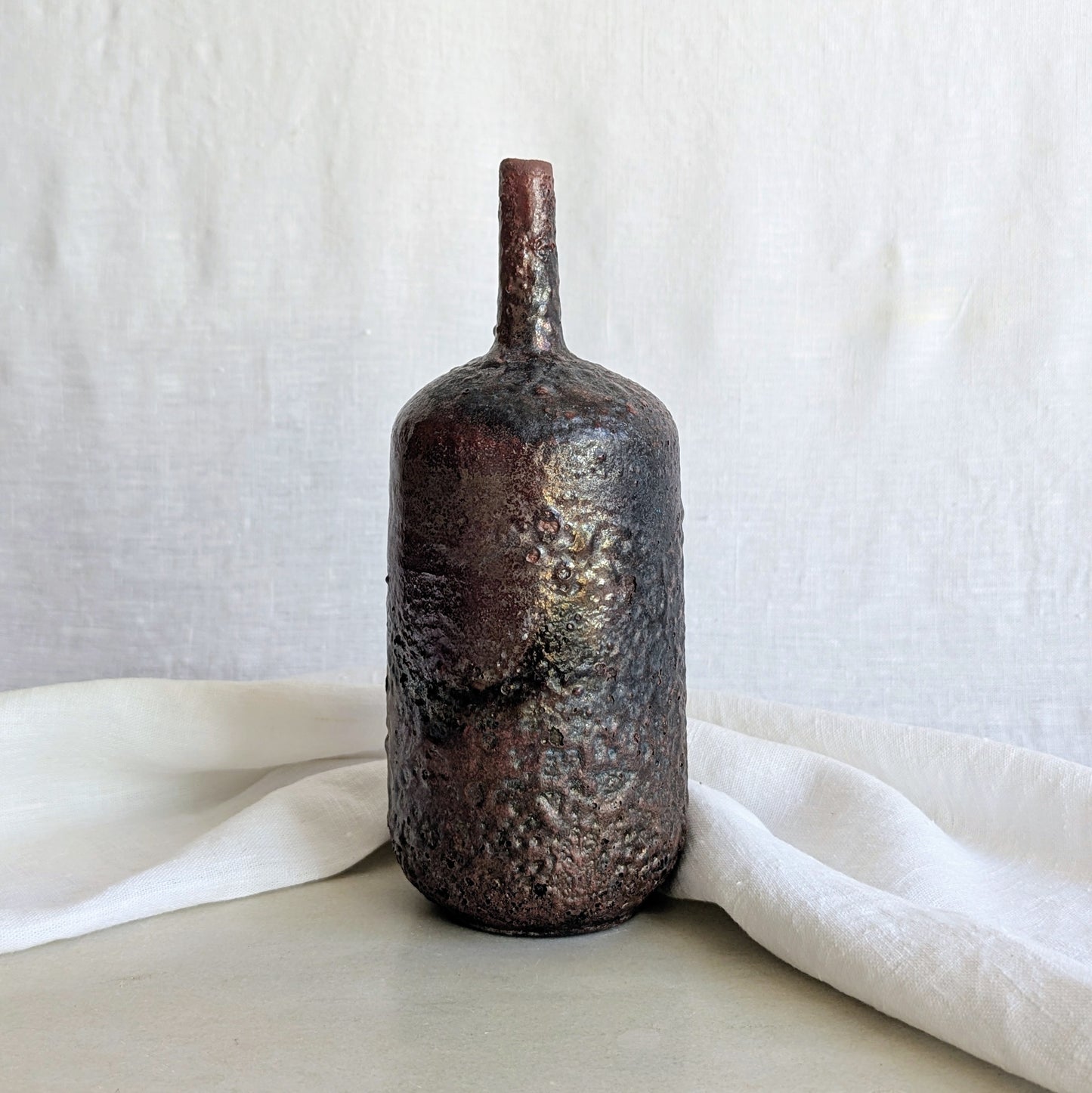 Pieza decorativa de cerámica rakú en gres blanco con acabado metálico hecha a mano por Laloba Cerámica