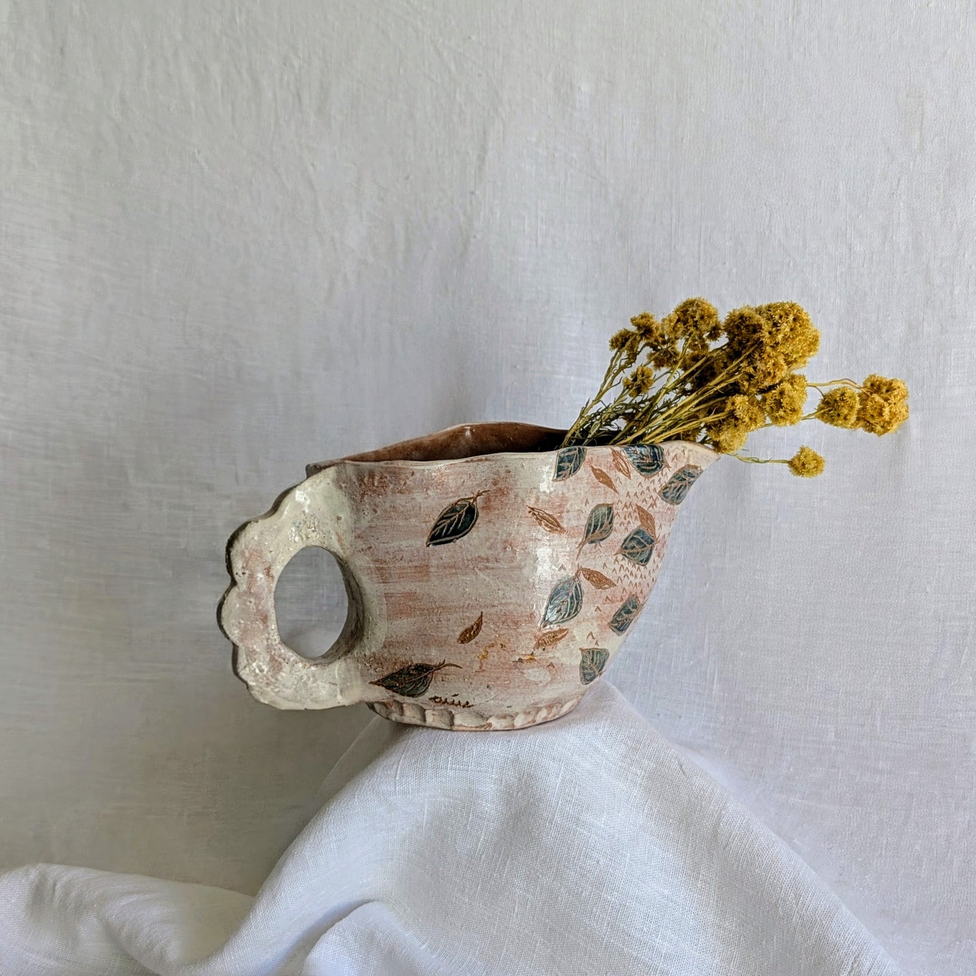 Pieza artesanal de barro rojo hecha a mano con técnica de churro y decoración esgrafiada de hojas naturales