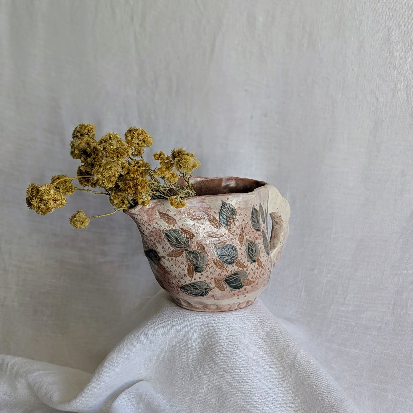 Pieza artesanal de barro rojo hecha a mano con técnica de churro y decoración esgrafiada de hojas naturales