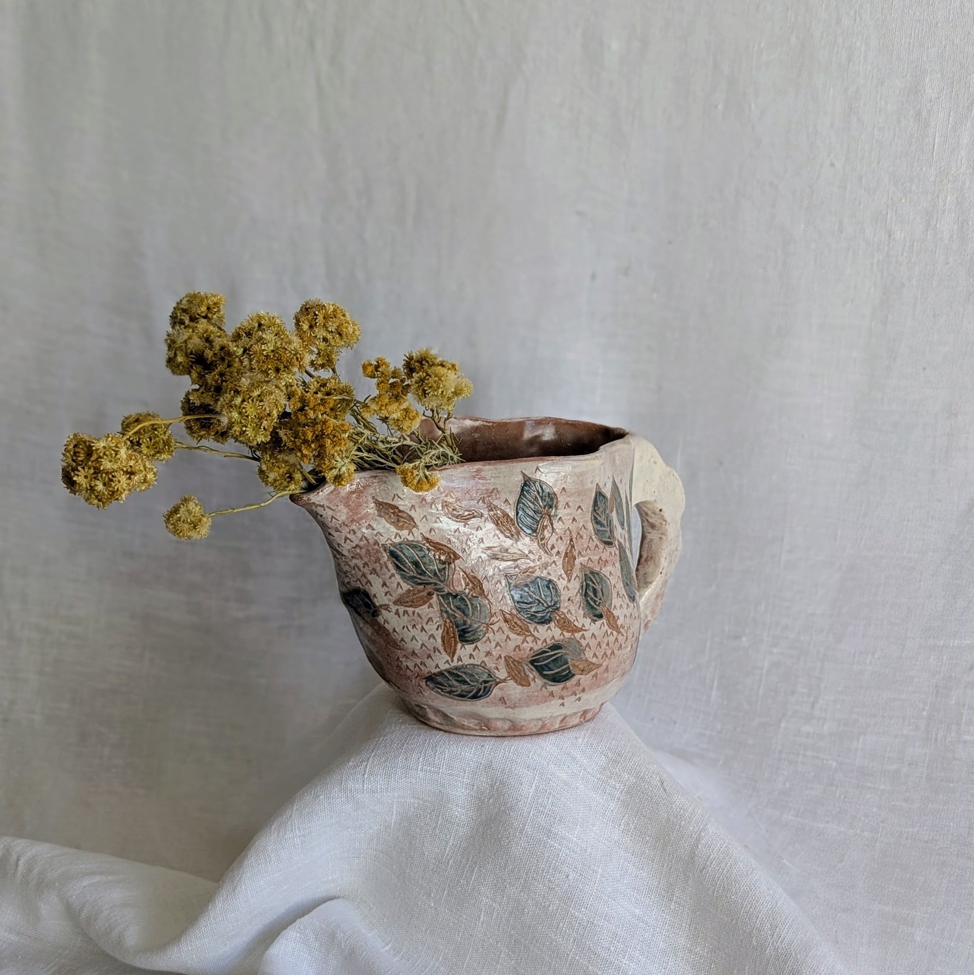 Pieza artesanal de barro rojo hecha a mano con técnica de churro y decoración esgrafiada de hojas naturales