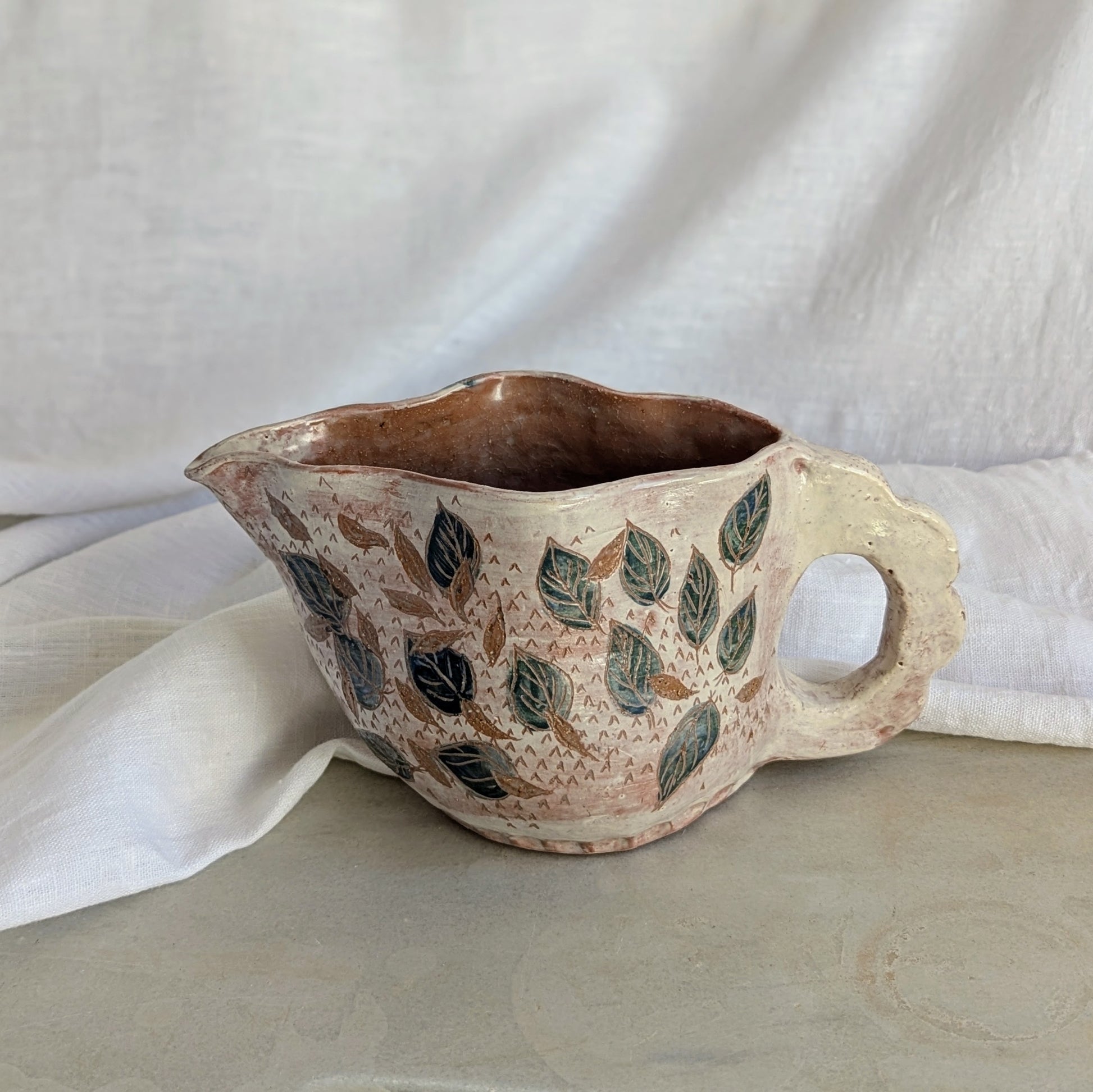 Pieza artesanal de barro rojo hecha a mano con técnica de churro y decoración esgrafiada de hojas naturales