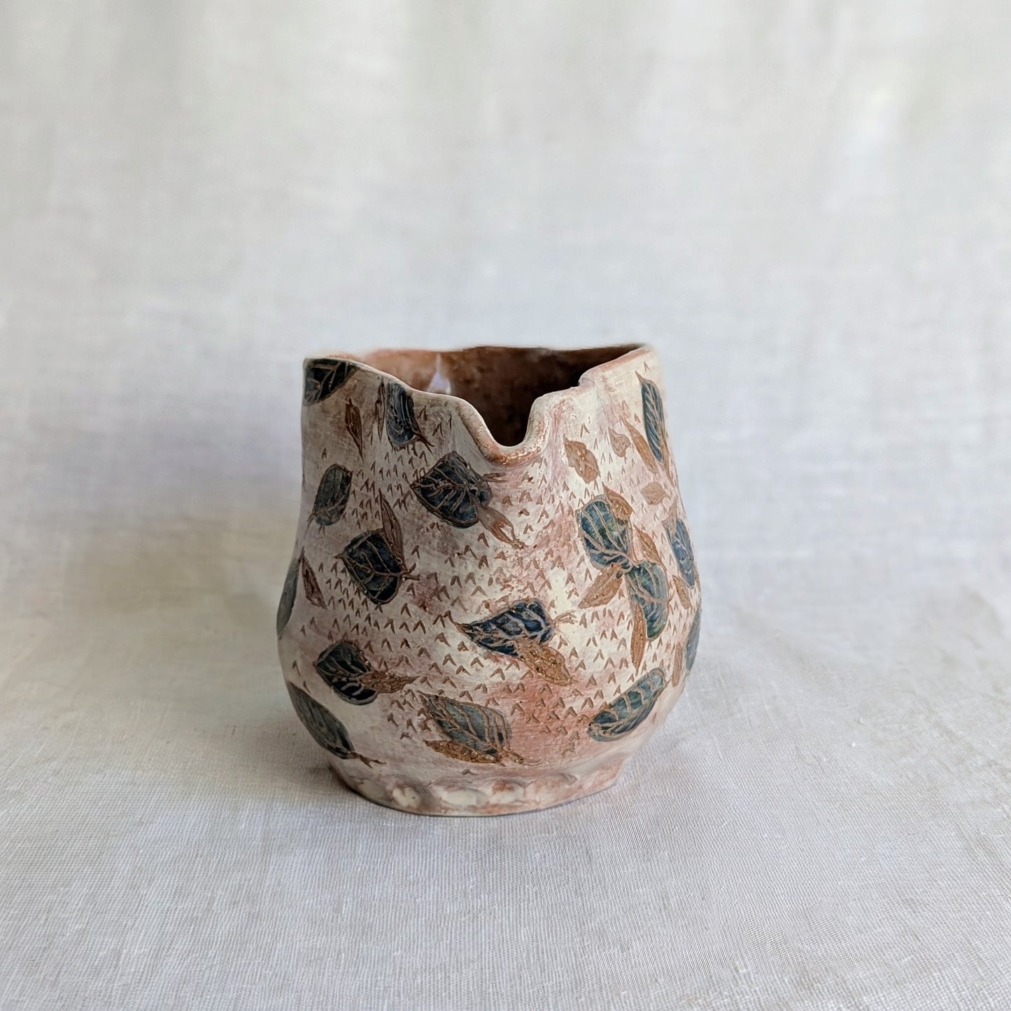 Pieza artesanal de barro rojo hecha a mano con técnica de churro y decoración esgrafiada de hojas naturales