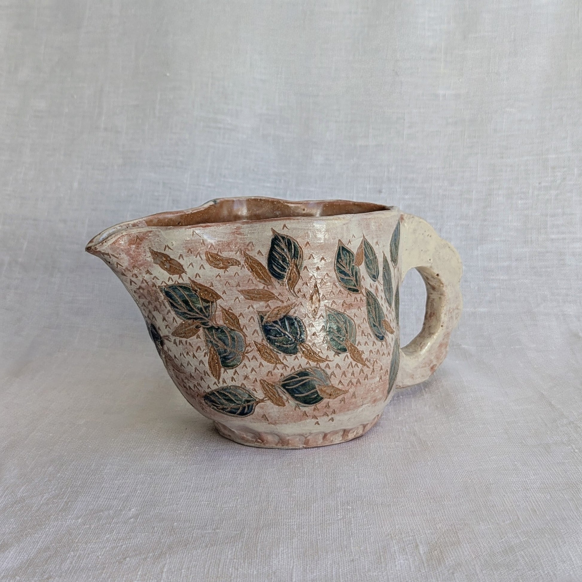 Pieza artesanal de barro rojo hecha a mano con técnica de churro y decoración esgrafiada de hojas naturales