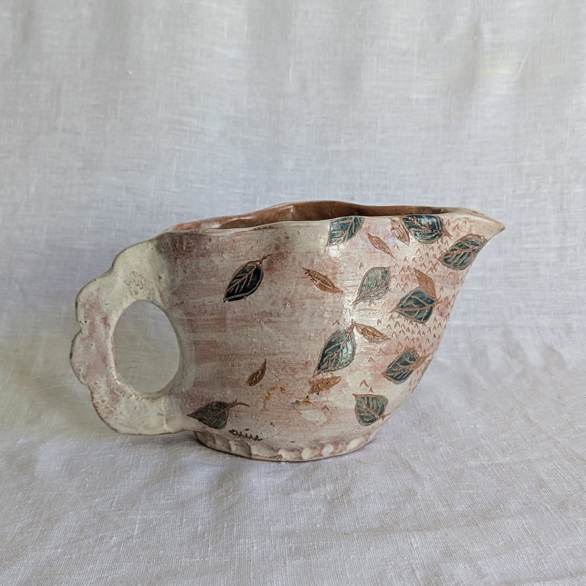 Pieza artesanal de barro rojo hecha a mano con técnica de churro y decoración esgrafiada de hojas naturales