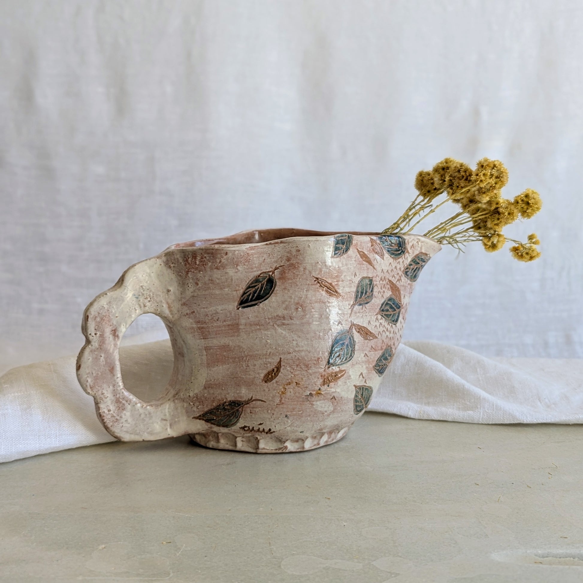 Pieza artesanal de barro rojo hecha a mano con técnica de churro y decoración esgrafiada de hojas naturales