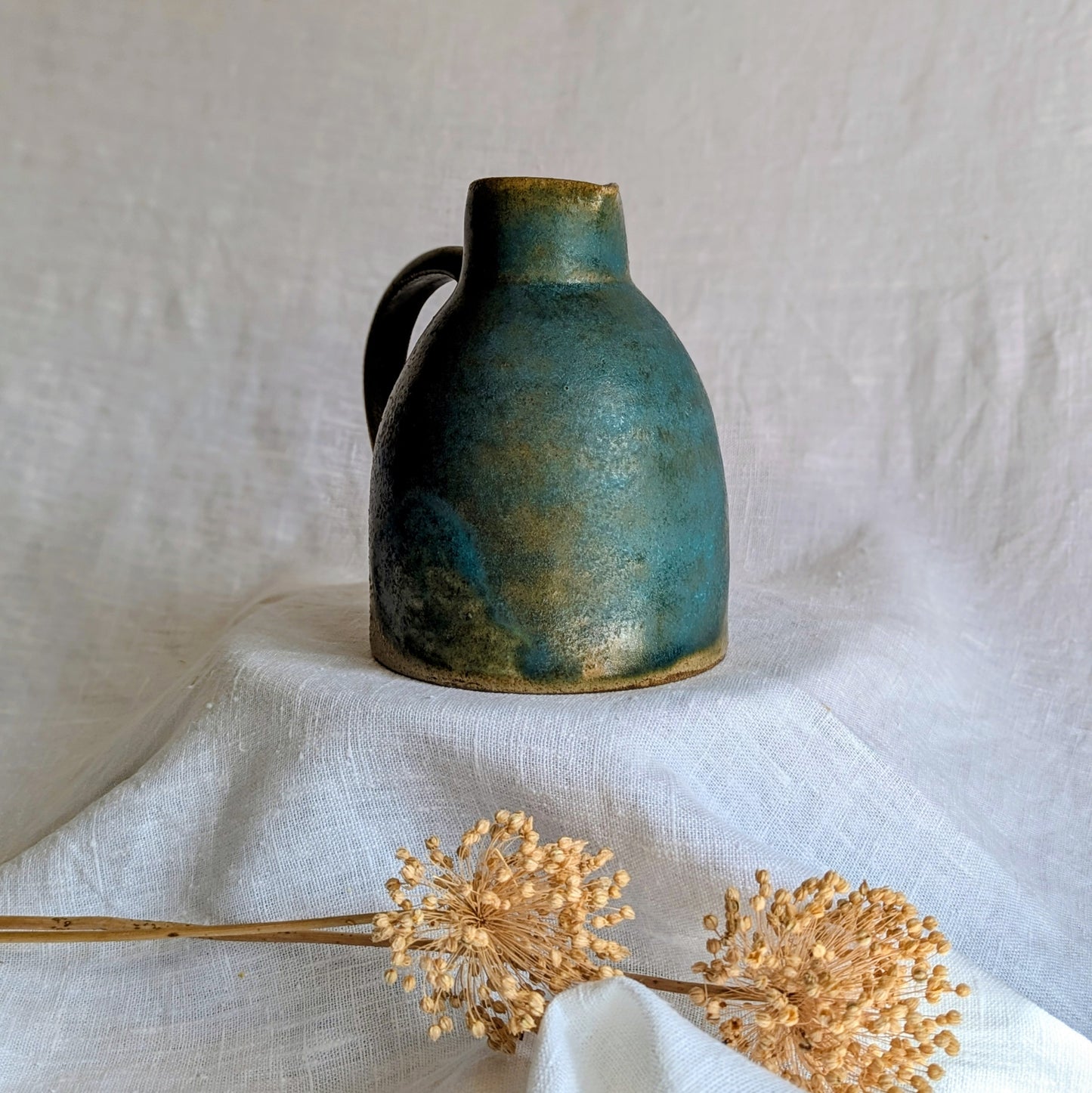 jarra artesanal en gres toffee esmaltado en tonos verdes y azulados, cerámica funcional contemporánea