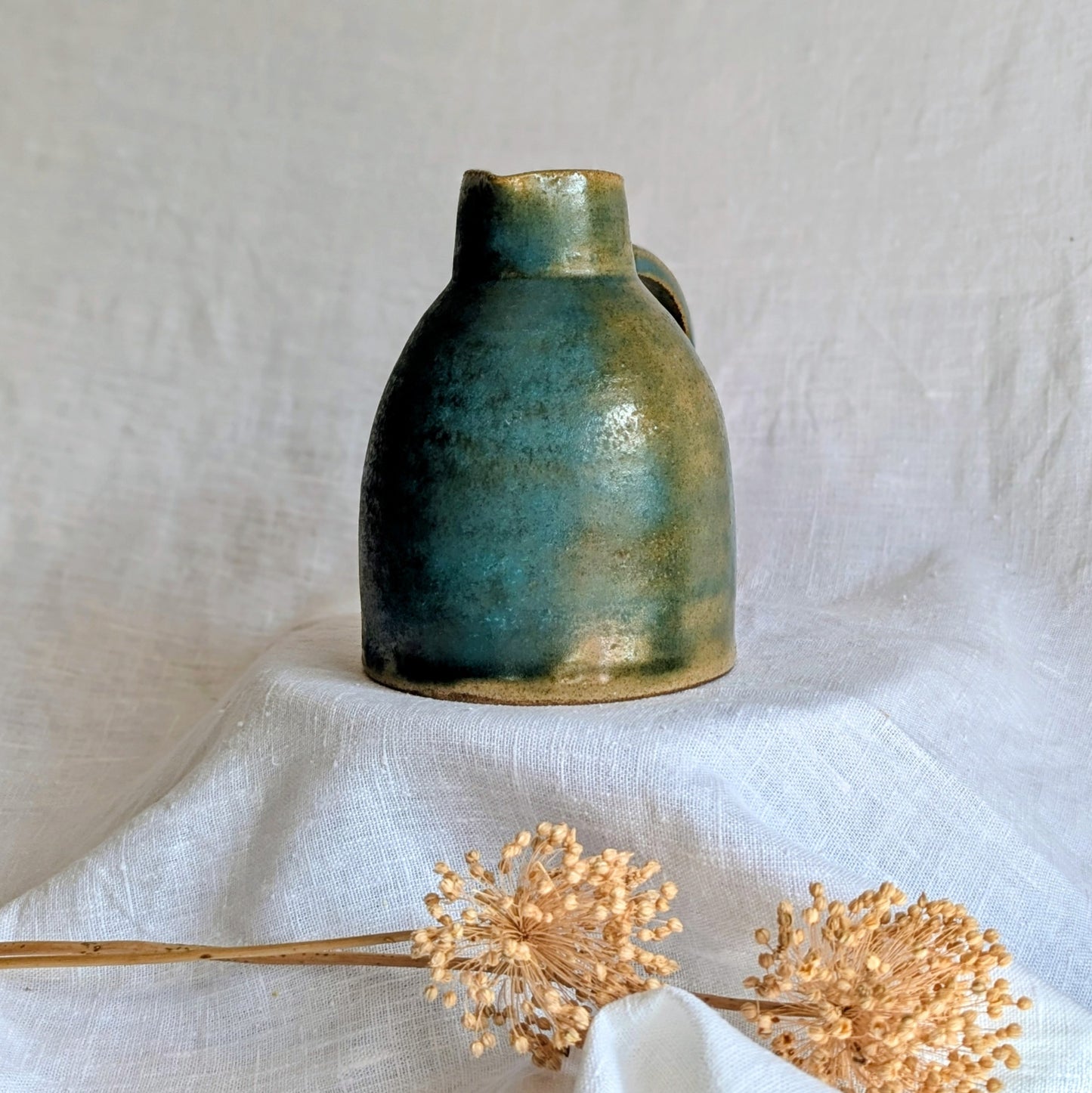 jarra artesanal en gres toffee esmaltado en tonos verdes y azulados, cerámica funcional contemporánea