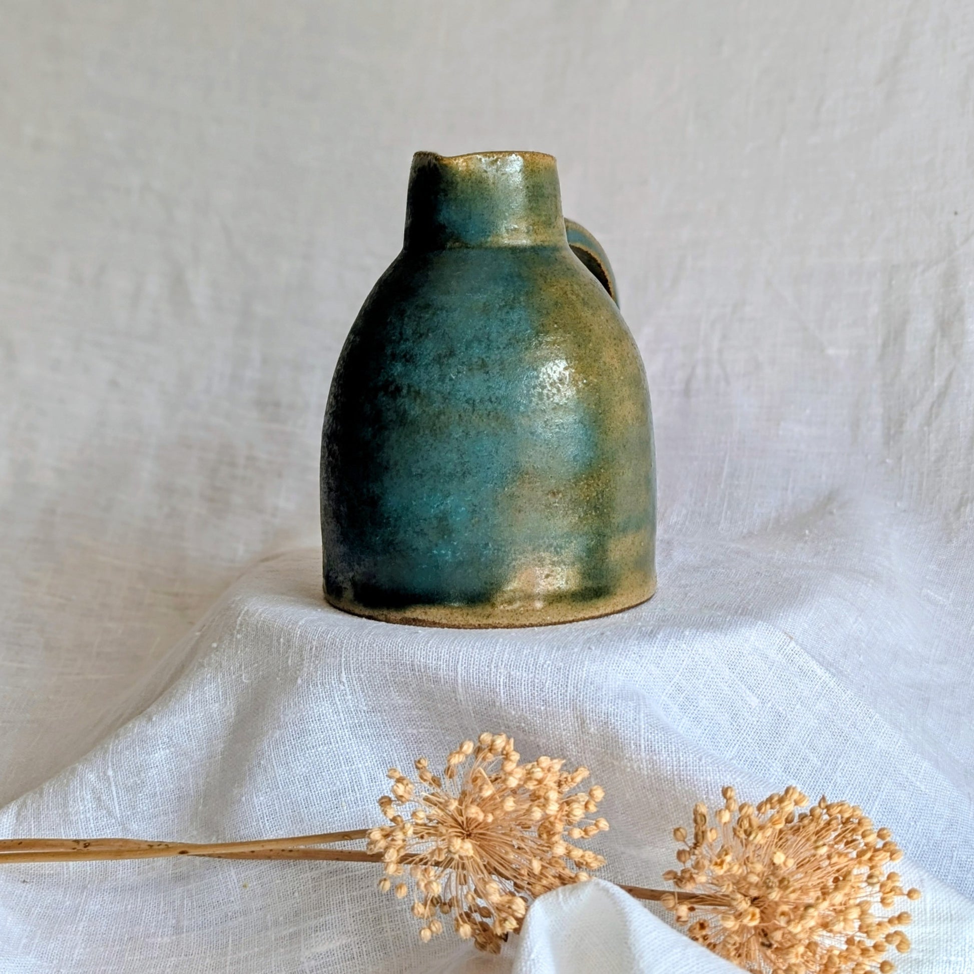 jarra artesanal en gres toffee esmaltado en tonos verdes y azulados, cerámica funcional contemporánea