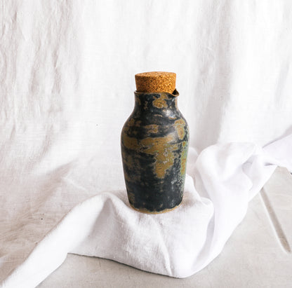 botella artesanal en terracota con esmalte verde reactivo y acabado moteado
