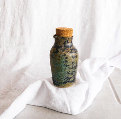 botella artesanal en terracota con esmalte verde reactivo y acabado moteado
